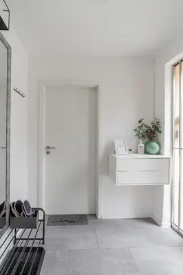a white room with a door and a bench at Classy & Cozy apartment 2 in Ljubljana