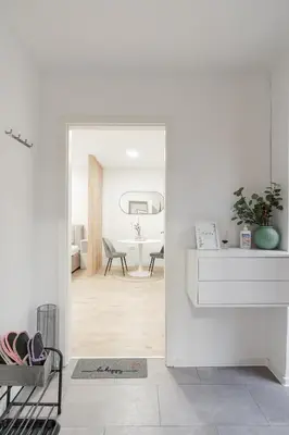 a hallway with a white room with a mirror at Classy & Cozy apartment 2 in Ljubljana