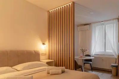 a bedroom with a bed and a table and a window at Classy & Cozy apartment 2 in Ljubljana
