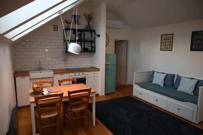 a kitchen and dining room with a table and a couch at Krakovska apartments in Ljubljana