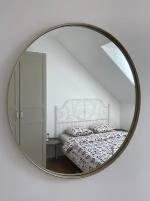 a mirror reflecting a bed in a white bedroom at Krakovska apartments in Ljubljana