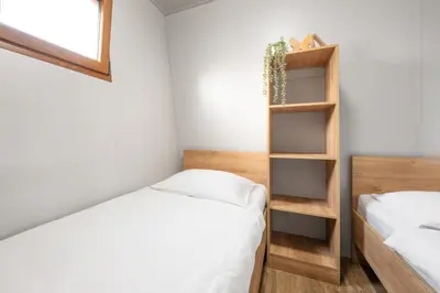 a small bedroom with two beds and a window at Terme Banovci - Mobilne hiške Med Brajdami in Banovci