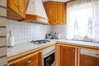 a kitchen with wooden cabinets and a stove top oven at Vineyard cottage Cvitkovič in Adlešiči