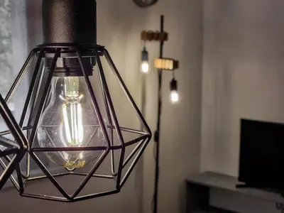 a hanging light in a living room with a lamp at Apartmaji Jakob 1 in Bovec