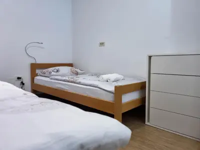 two twin beds in a room with a mirror at Apartmaji Jakob 1 in Bovec