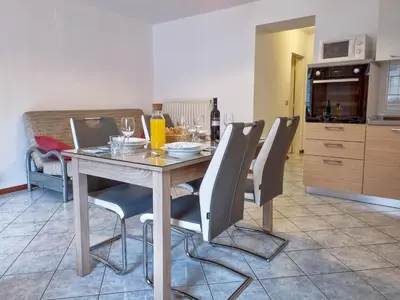 a dining room table with chairs and wine glasses at Apartmaji Jakob 1 in Bovec