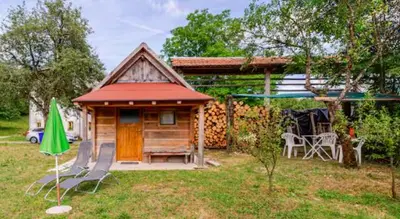a small cabin with a table and chairs in a yard at Beehive cabin on a farm in Radovljica