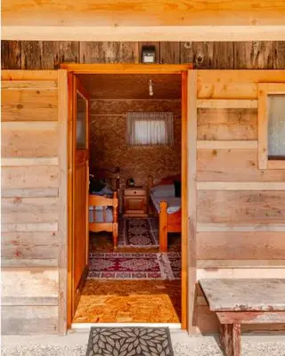 an open door to a bedroom in a wooden cabin at Beehive cabin on a farm in Radovljica