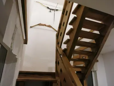 a wooden staircase in a room with a white wall at Turistična kmetija Izgoršek in Griže