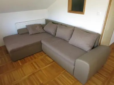 a couch with two pillows on it in a room at Turistična kmetija Izgoršek in Griže