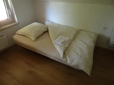 a bed with two pillows on it in a room at Turistična kmetija Izgoršek in Griže