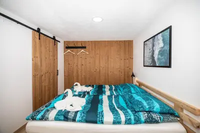 a bedroom with a bed with a blue and white blanket at Apartment in Škofja Loka in Škofja Loka