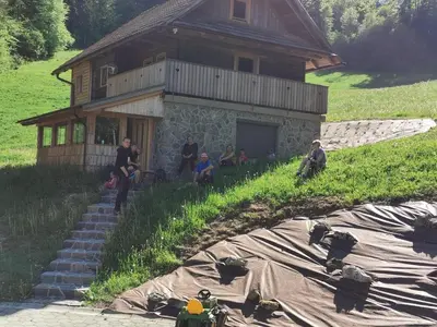 a group of people sitting in front of a house at APARTMA BREST in Gornji Grad