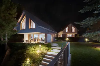 a house with lights on the lawn at night at Ambient Resort Bled in Bled