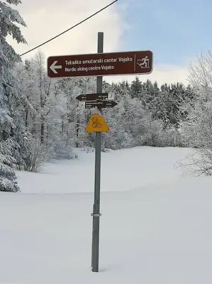 a street sign on a pole in the snow at Sanjska Hiša Vojsko in Idrija