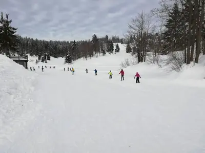 a group of people skiing in the snow at Sanjska Hiša Vojsko in Idrija