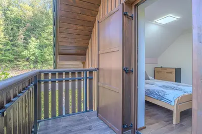 a room with a bed on a balcony at Resort Stari Malni, Osilnica - vacation houses Stari Malni in Osilnica