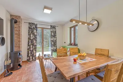 a dining room with a wooden table and a fireplace at Resort Stari Malni, Osilnica - vacation houses Stari Malni in Osilnica