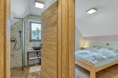 a bedroom with a king sized bed and a shower at Resort Stari Malni, Osilnica - vacation houses Stari Malni in Osilnica