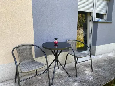 two chairs and a table with a vase on it at Cara's house in Ljubljana