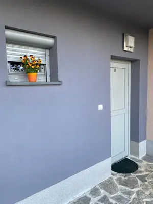 a blue wall with a window with a flower pot on it at Cara's house in Ljubljana