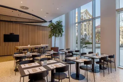 a restaurant with tables and chairs and windows at Occidental Ljubljana in Ljubljana