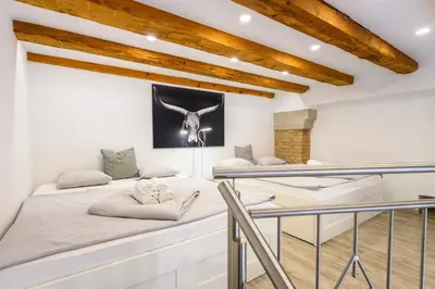 a bedroom with two beds and a table at The Happy Loft in Ljubljana