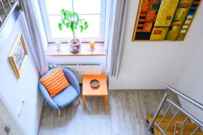a small room with a blue chair and a table at The Happy Loft in Ljubljana