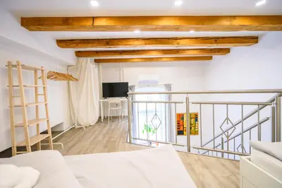 a living room with a white couch and a balcony at The Happy Loft in Ljubljana