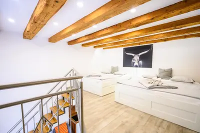 two beds in a room with wooden ceilings at The Happy Loft in Ljubljana