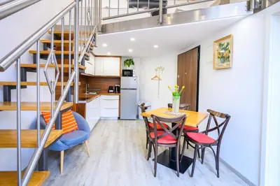 a kitchen and dining room with a staircase and a table and chairs at The Happy Loft in Ljubljana