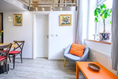a living room with a blue chair and a table at The Happy Loft in Ljubljana