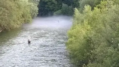 two people are in the water on a river at Savinja River Residence in Ljubno