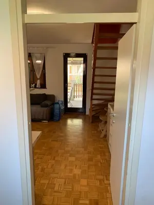 a hallway with a staircase and a living room at Lotty in Čatež ob Savi