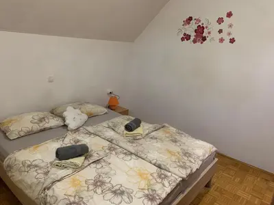 a bedroom with a bed with a stuffed animal on it at Lotty in Čatež ob Savi