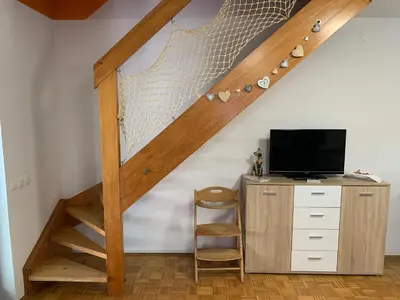 a staircase in a room with a desk and a television at Lotty in Čatež ob Savi