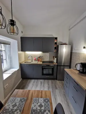 a kitchen with black cabinets and a stainless steel refrigerator at Belavita in Bovec