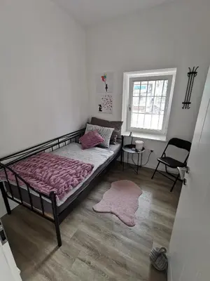 a bedroom with a bed and a chair and a window at Belavita in Bovec