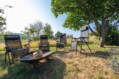 a group of chairs and a table and a tree at Cottage near river Kolpa, vineyards,top location. in Adlešiči