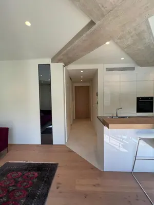a kitchen with white cabinets and a wooden floor at Castle View Luxury Suite in Ljubljana