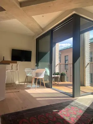 a living room with sliding glass doors leading to a patio at Castle View Luxury Suite in Ljubljana