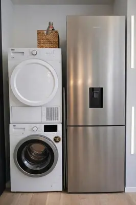 a stainless steel refrigerator next to a washing machine at Keleia Nova Vas Design Apartment Celje in Celje