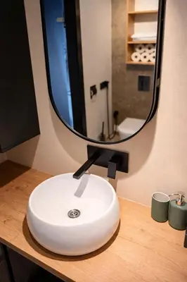 a bathroom sink with a mirror on a counter at Keleia Nova Vas Design Apartment Celje in Celje