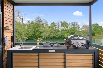 a kitchen with a view of a lake through a window at Glamping Lucky House in Gradac