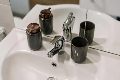 a bathroom sink with three coffee mugs on it at Glamping Lucky House in Gradac