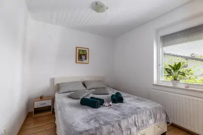 a bedroom with a bed with two blue towels on it at Apartment Dalija - Cosy Apartment & Rooms with Massage Studio in Podčetrtek