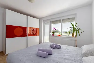 a bedroom with two purple pillows on a bed at Apartment Dalija - Cosy Apartment & Rooms with Massage Studio in Podčetrtek