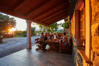 a group of people sitting at a table on a patio at Ferjančič estate rooms in Ajdovščina