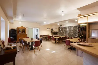 a restaurant with tables and chairs and wine bottles at Ferjančič estate rooms in Ajdovščina