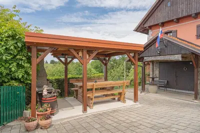 a wooden pavilion with a bench on a patio at Vineyard Cottage Vesna Lake View - Happy Rentals in Veliki Vrh
